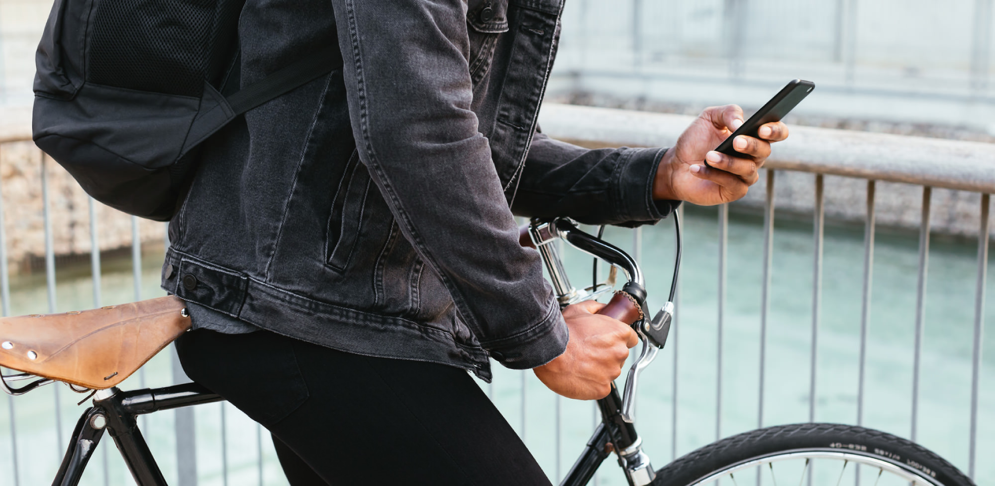 Young man in urban setting using mobile device to access doctors virtually through the Maple native app